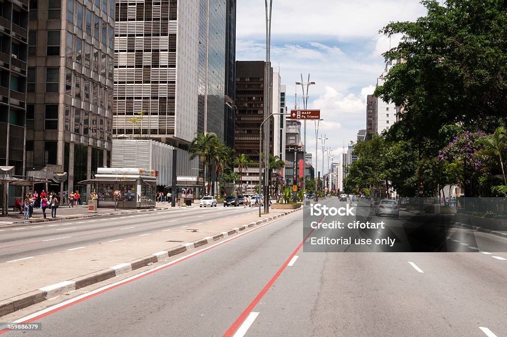 Paulista Avenue in Sao Paulo, Brazil Sao Paulo, Brazil - February 12, 2013: Paulista Avenue in the city of Sao Paulo, a leading financial, cultural and entertainment centers of the city, with many office buildings along the avenue. On a sunny summer day, with some people walking by foot or car. Architecture Stock Photo