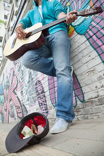 istock Young street musician playing guitar 459887083