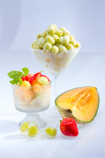 Frozen fruit salad served in frosted glass .