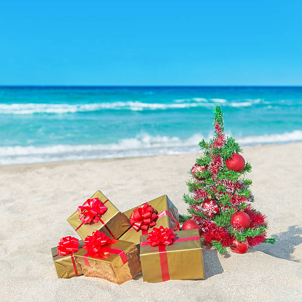 istock Christmas tree and many gift boxes on sea beach 459893411