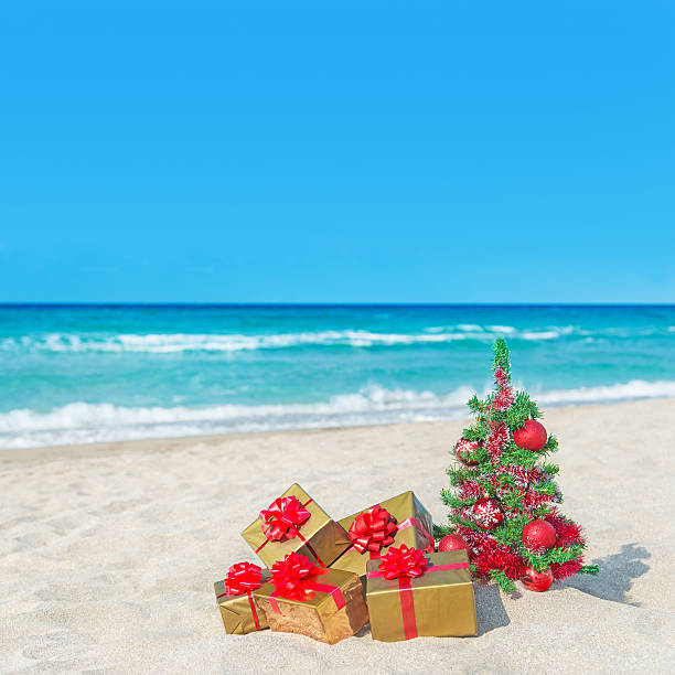 istock Christmas tree and many gift boxes on sea beach 459893427