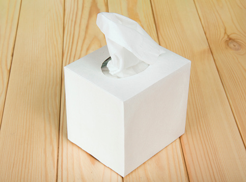 The white box with napkins on wooden table