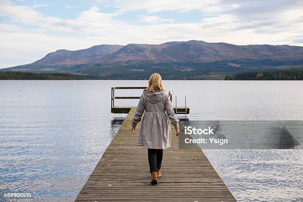Lonely Woman Walking On A Pier Stock Photo - Download Image Now - Adult, Adults Only, Autumn