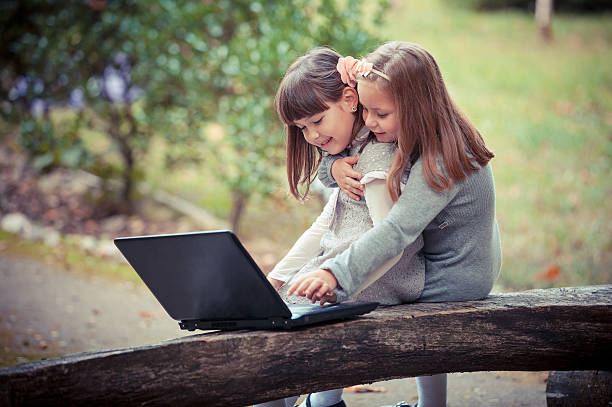 istock girlfriend in autumn park with laptop 459904339