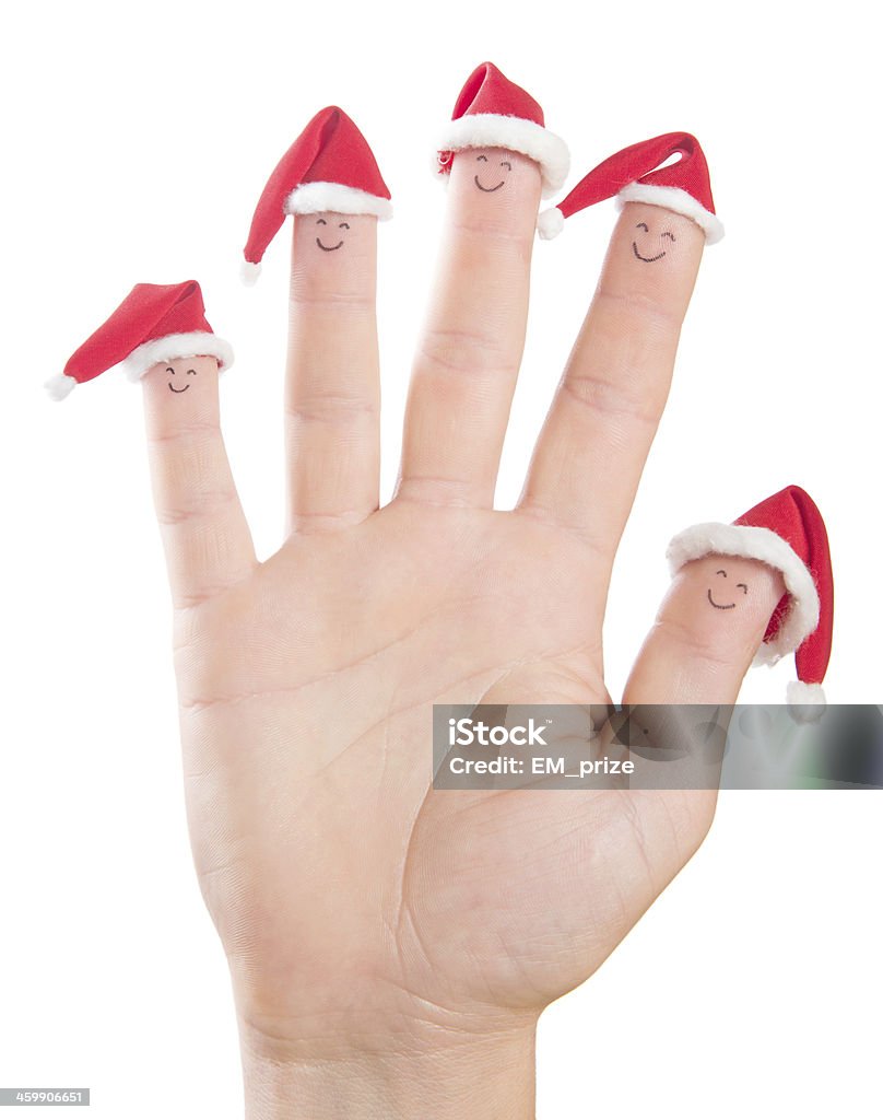 指のクリスマスサンタ帽子に面しています。 - お祝いのロイヤリティフリーストックフォト
