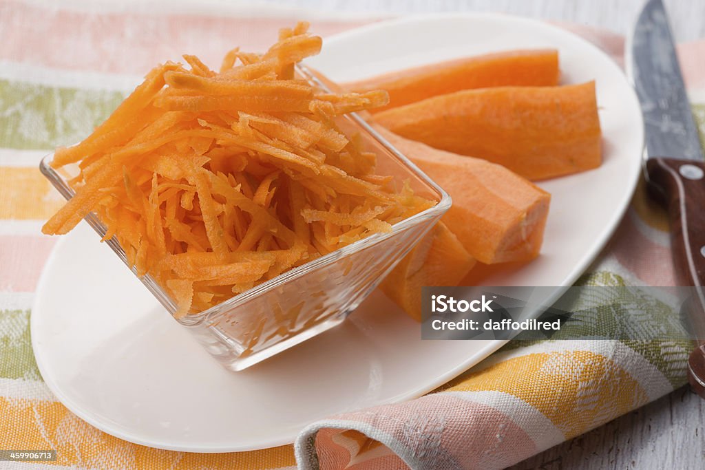 Grated carrots on board Grated carrots on white plate. Selective focus. Backgrounds Stock Photo