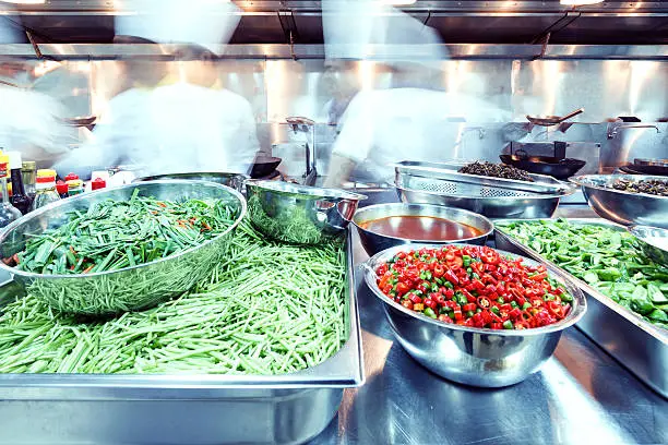 Photo of Two busy chefs in a restaurant kitchen