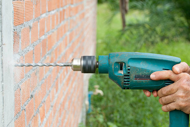 istock Drilling the wall with electric drill 1 459910233