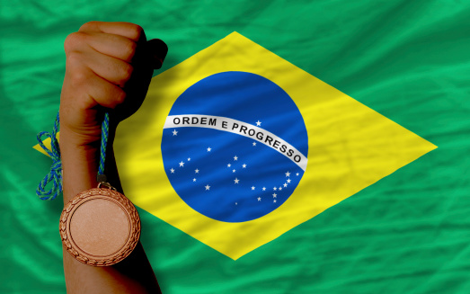 Holding bronze medal for sport and national flag of brazil