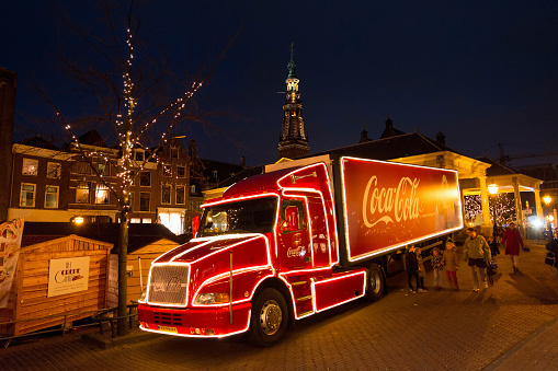 Leiden, The Netherlands - December 16, 2013: People walking past a beautiful Christmas Coca Cola truck at the Christmas market at night in Leiden, the Netherlands, on December 16th 2013