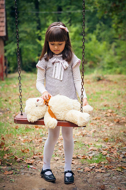 istock Small beautiful girl and amusing bear 459916483