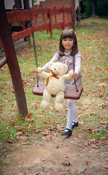 istock Small beautiful girl and amusing bear 459921425