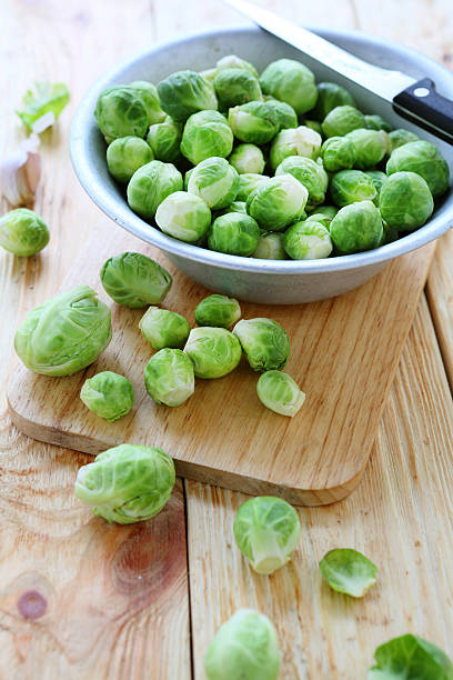 primas bruselas sprouts en un tazón - brussels sprout raw brown close up fotografías e imágenes de stock