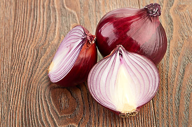 istock Fresh red onions on a wooden background 459923635
