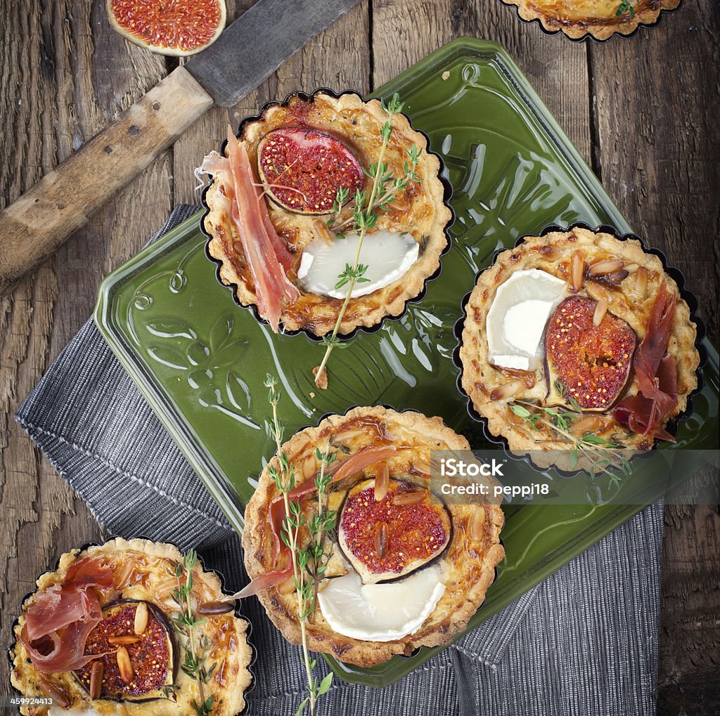 homemade tart homemade tart or quiche with figs, ham, cheese and thyme on rustic wooden board on green plate, birds eye view Fig Stock Photo