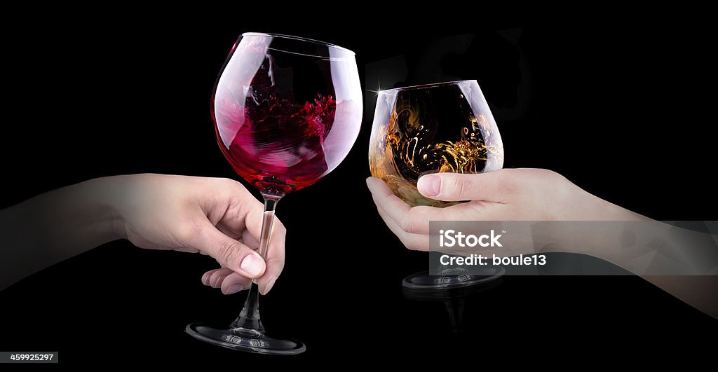 hand making toast with alcohol hand making toast with glass of red splashing wine and brandy on black background Wine Stock Photo