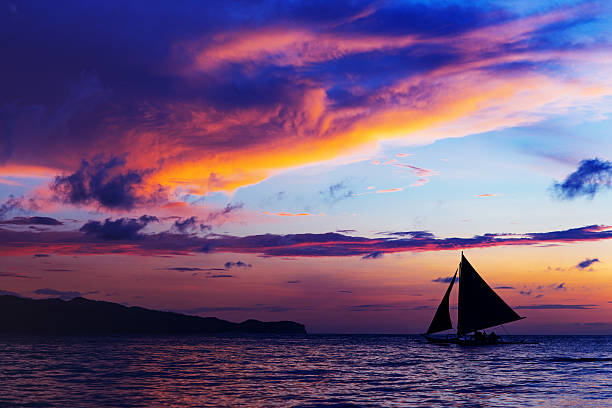 Amazing colorful sunset at sea. Sailboat. White beach, Boracay, Philippines