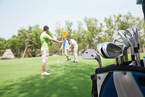 tre amici a giocare a golf, concentrarsi sui caddy - golf putting determination focus foto e immagini stock