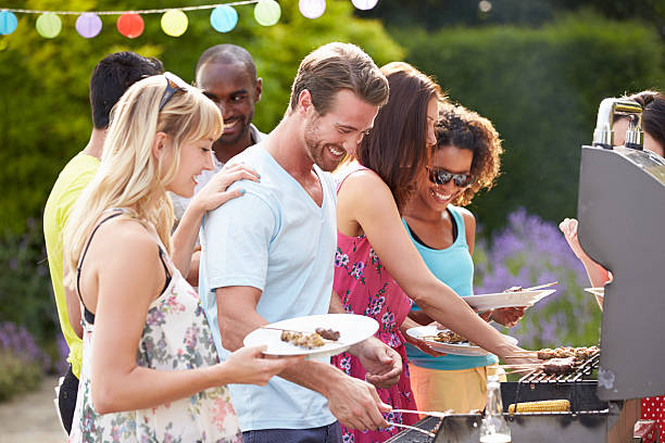 Group Of Friends Having Outdoor Barbeque At Home Group Of Friends Having Outdoor Barbeque At Home In Garden barbecue social gathering photos stock pictures, royalty-free photos & images