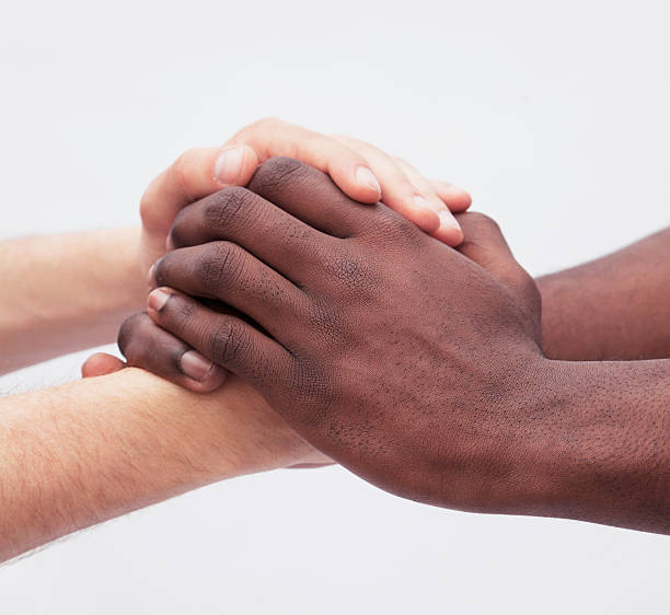 istock Two young men clasping each others hands, close-up, studio shot 459926823