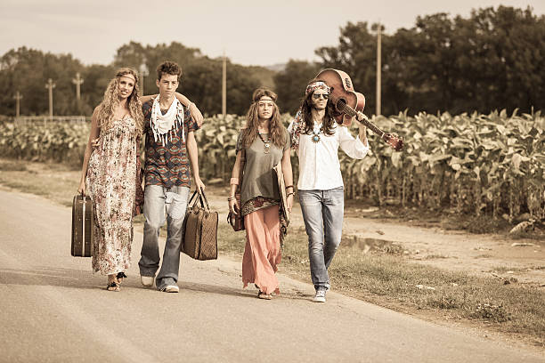 hippy grupo pasos en una campiña calle - 1970s style women hippie retro revival fotografías e imágenes de stock