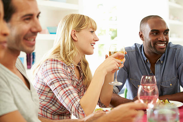 istock Group Of Friends Sitting Around Table Having Dinner Party 459928003
