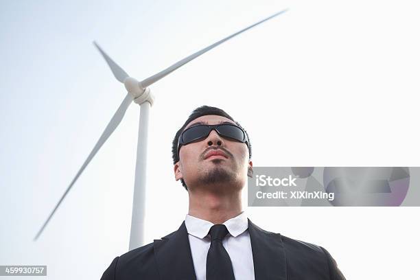 Businessman In Sunglasses Standing By A Wind Turbine Stock Photo - Download Image Now