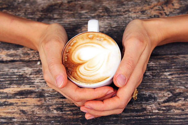 istock woman hands with cappuccino  on a wood table 459933449