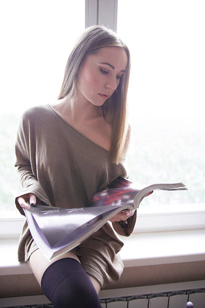 istock girl sitting on a window sill 459934489