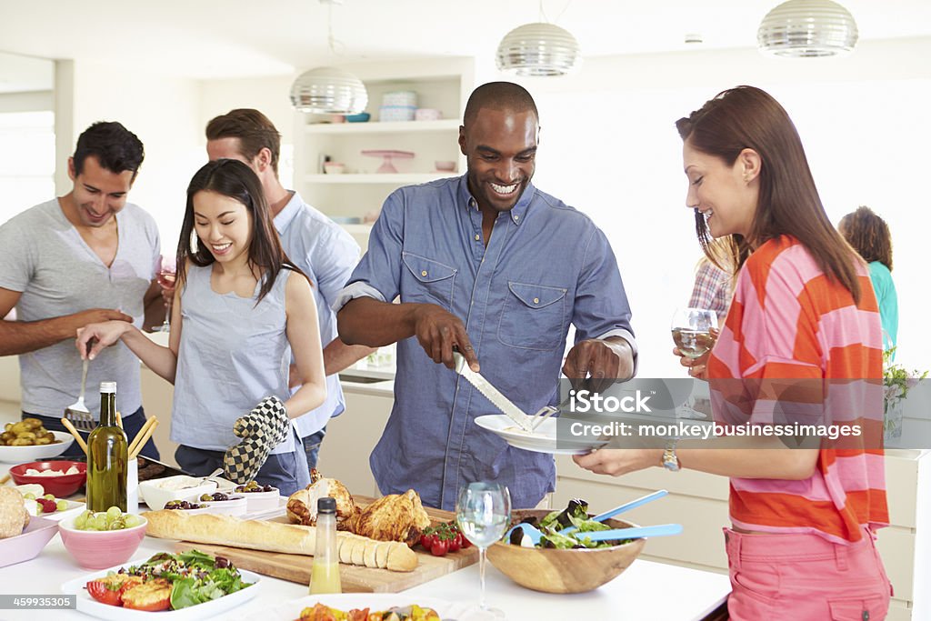 Group Of Friends Having Dinner Party At Home Group Of Friends Having Dinner Party At Home Serving Food 20-29 Years Stock Photo