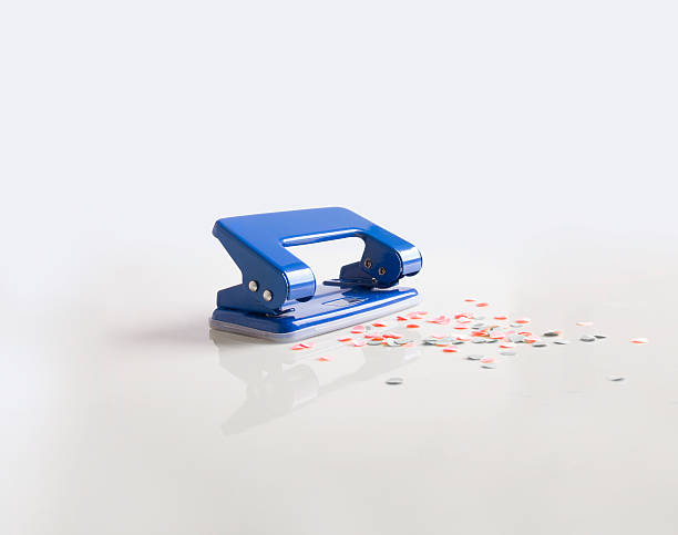 paper punch piercing blue paper hole puncher stock pictures, royalty-free photos & images