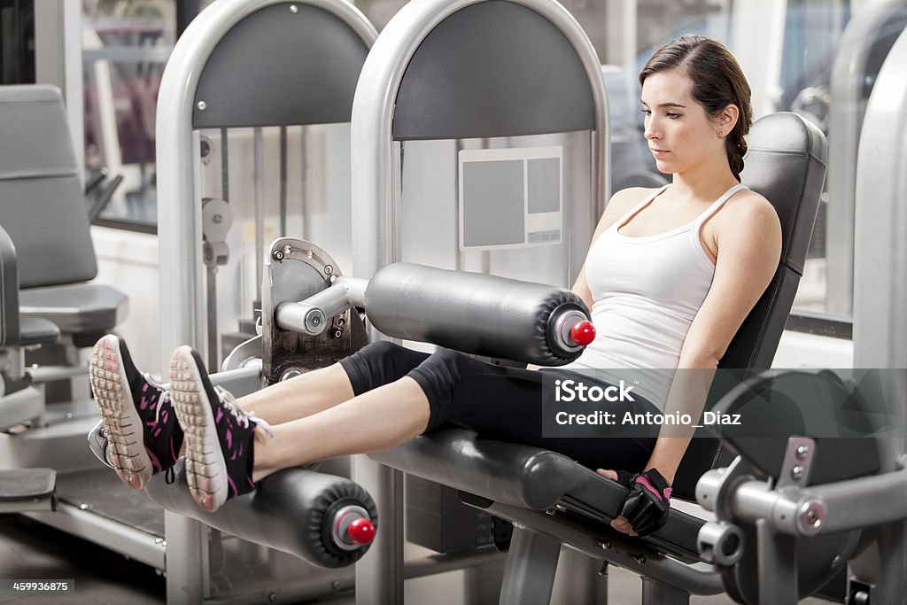 Pretty girl working in a simulator Cute young Latin woman doing a leg workout in a simulator at the gym 20-29 Years Stock Photo