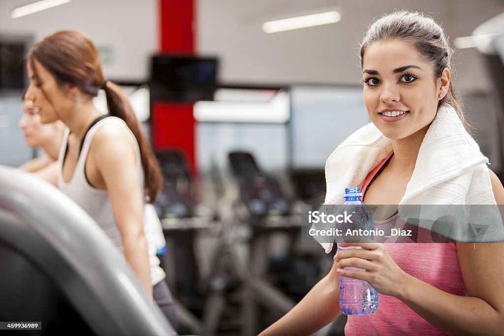 Cooling off after working out Cute Hispanic brunette relaxing and drinking water after a workout at the gym 20-29 Years Stock Photo