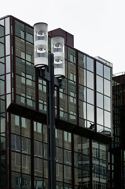The abstract reflection of street lights in the glass facade of a modern home.