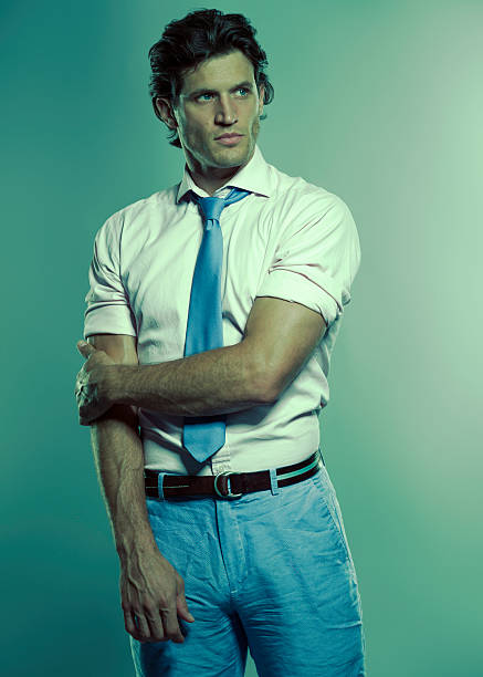 man in blue tie and pants holding arm with a blue green tint