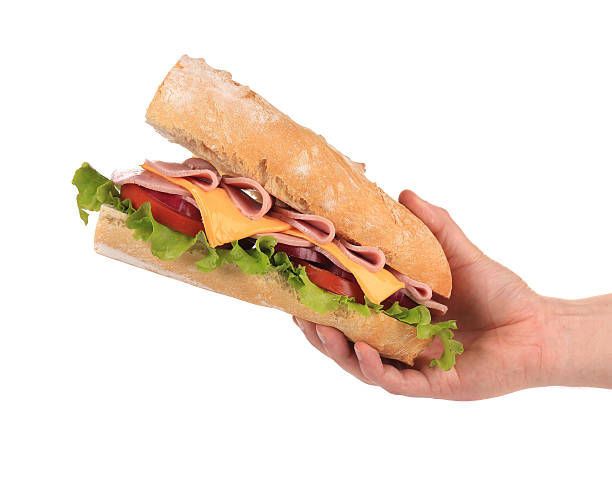 istock Hand holds french baguette sandwich. 459948733