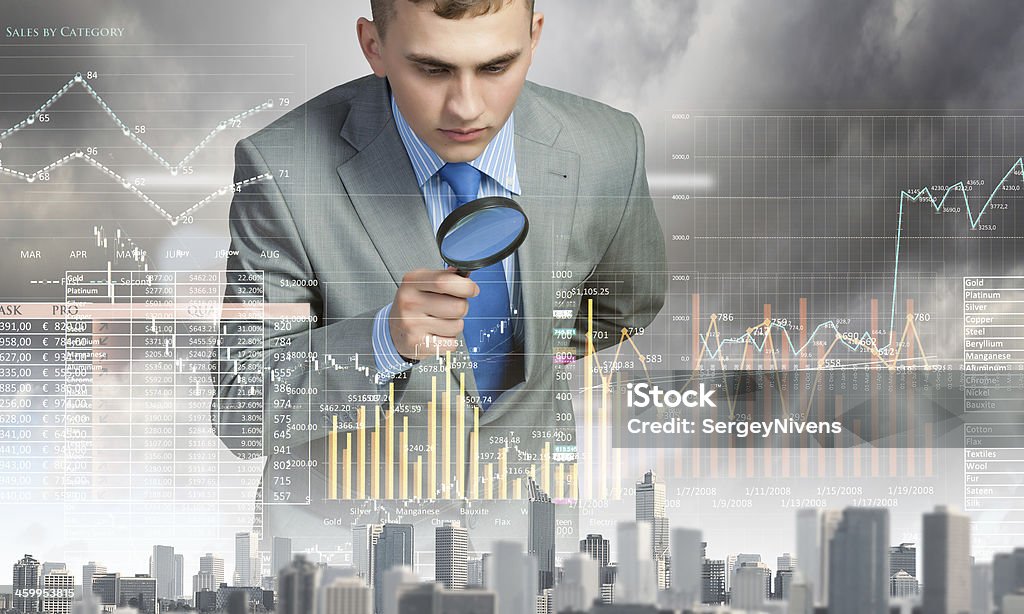 A man looking through a magnifying glass at a graph Image of businessman examining objects with magnifier Demography Stock Photo