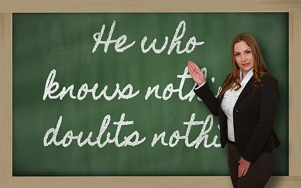istock Teacher showing He who knows nothing, doubts on blackboard 459956903