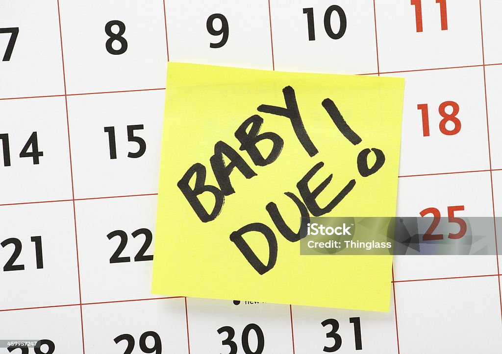 Baby Due Date Reminder Baby Due Date Reminder written on a yellow sticky paper note and stuck to a wall calendar background Adhesive Note Stock Photo