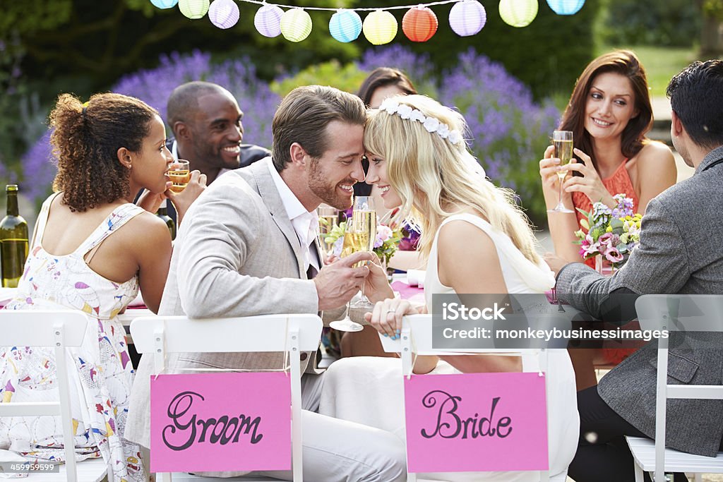 Bride And Groom Enjoying Meal At Wedding Reception Bride And Groom Enjoying Meal At Wedding Reception With Friends Wedding Stock Photo