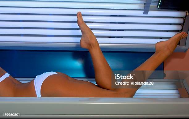 A Woman Sunbathing On A Sun Lounger Stock Photo - Download Image Now - Tanning Bed, Brown, Adult