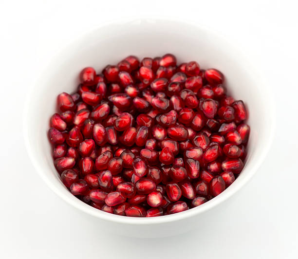istock Bowl of ripe pomegranate seeds against white 459961695