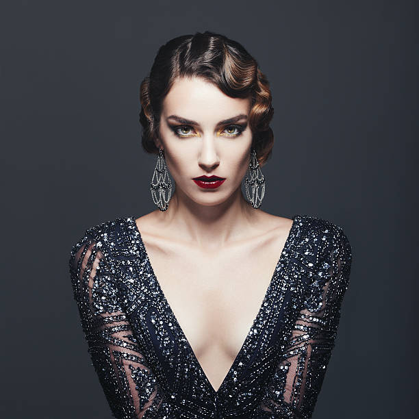 Glam retro diva Studio portrait of beautiful glamourous  woman wearing shiny dress. 20's - 30's styled image. Professional make-up and hairstyle. High-end retouch. vintage hairstyle stock pictures, royalty-free photos & images