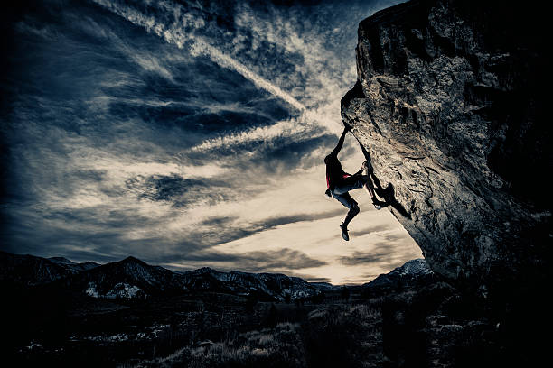 sepia Rock climbing in a dramatic setting.  clambering stock pictures, royalty-free photos & images