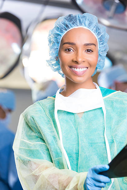 Confident female surgeon standing in operating room before operation Confident female surgeon standing in operating room before operation operating room photos stock pictures, royalty-free photos & images