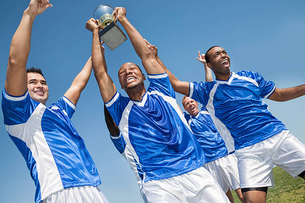 istock Victorious soccer team holding trophy and celebrating win 459964911