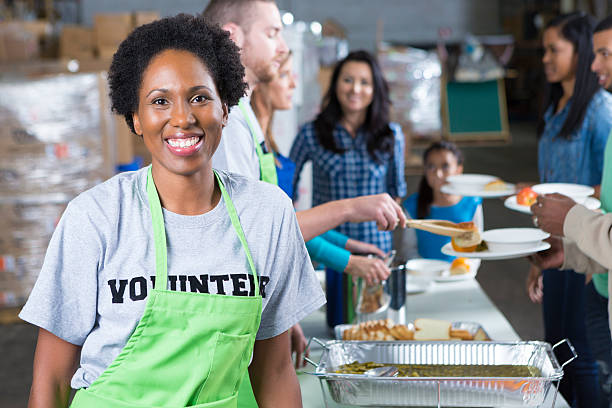 African American woman volunteering at community soup kitchen African American woman volunteering at community soup kitchen soup kitchen stock pictures, royalty-free photos & images