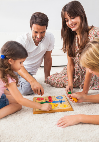 Family playing board game on the floor