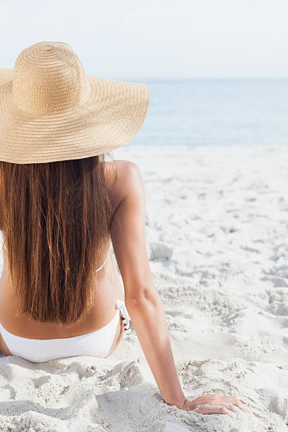 istock Woman on holiday wearing sunhat looking at ocean 459965685