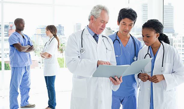 istock Mature doctor giving explanations to interns with colleagues in 459967847